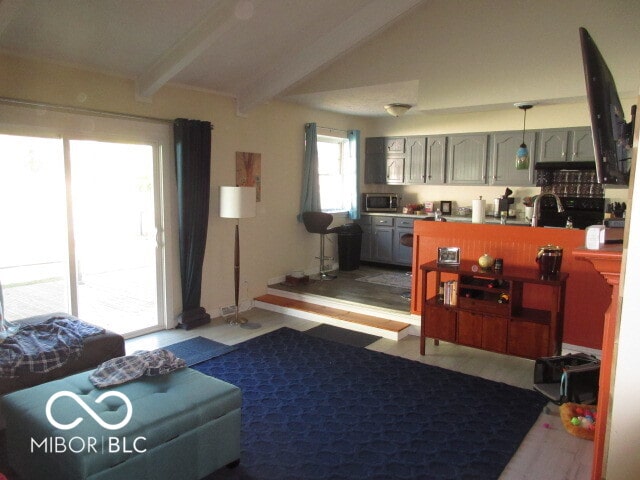 living room featuring sink and lofted ceiling with beams