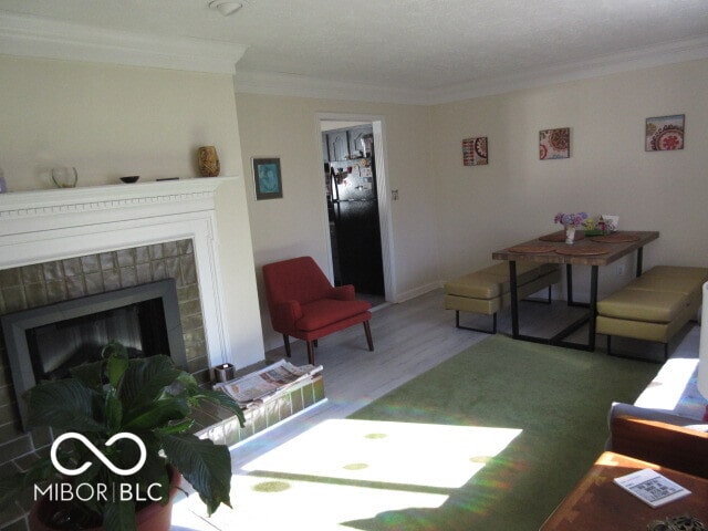 living room with ornamental molding, a textured ceiling, and a fireplace