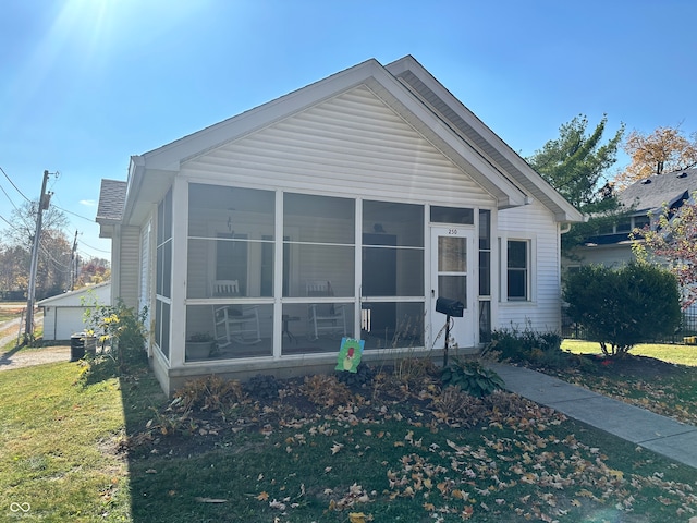 view of front of house featuring a sunroom and a front lawn