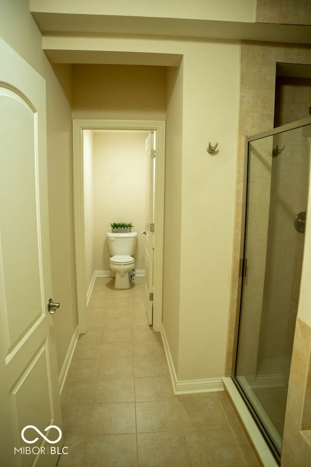 bathroom featuring walk in shower, tile patterned floors, and toilet