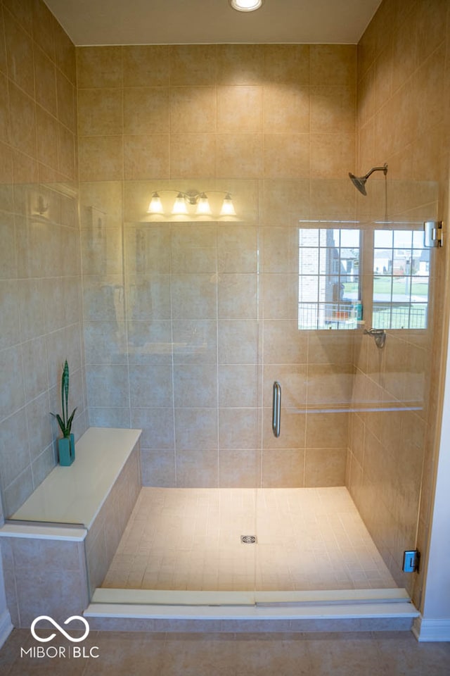 bathroom with tile walls, tile patterned floors, and a shower with shower door