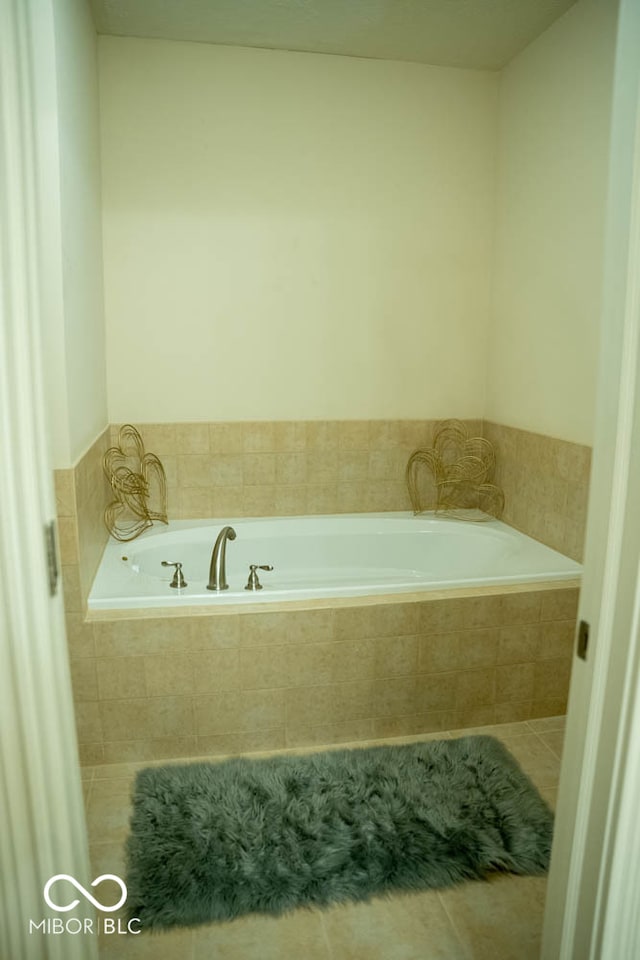 bathroom with tiled bath and tile patterned flooring