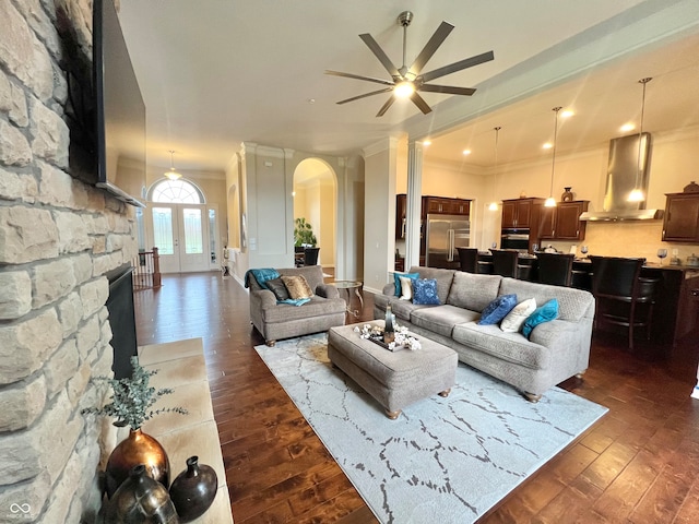 living room featuring dark hardwood / wood-style flooring, ceiling fan, and crown molding