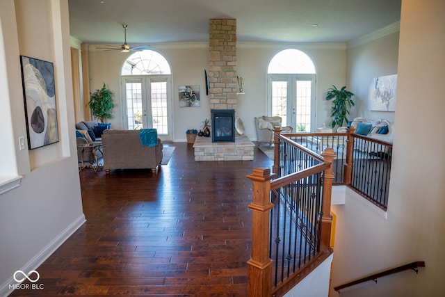 living room with a wealth of natural light, crown molding, french doors, and dark hardwood / wood-style flooring