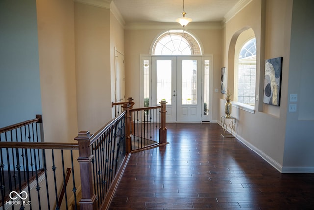 foyer with plenty of natural light, dark wood-type flooring, and crown molding