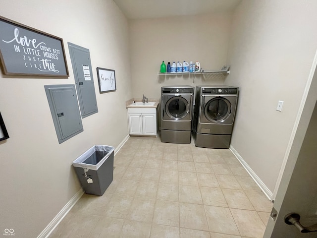 laundry area featuring electric panel, cabinets, light tile patterned floors, sink, and washing machine and clothes dryer