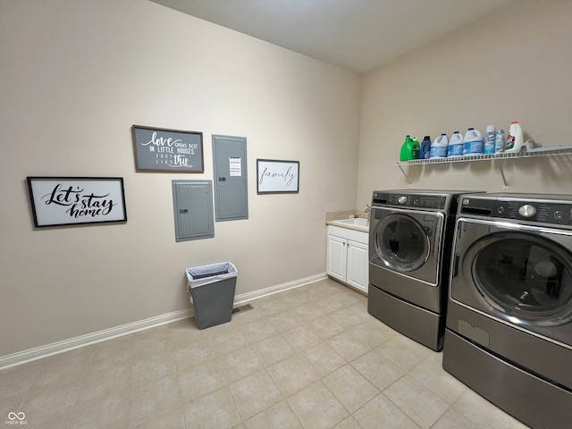 washroom featuring electric panel, washing machine and dryer, cabinets, and sink