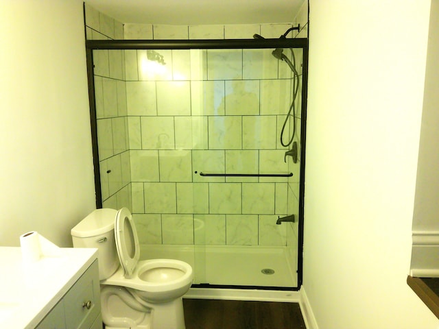 bathroom with an enclosed shower, vanity, and toilet