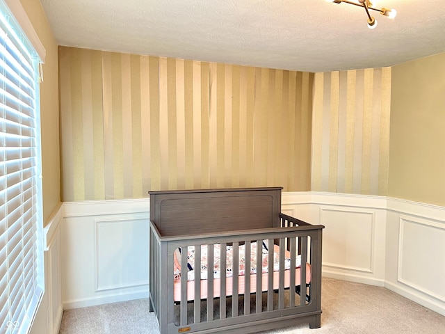 5778 W Commonview Dr, Mccordsville, IN 46055 - carpeted bedroom with wallpapered walls, wainscoting, a textured ceiling, and a nursery area