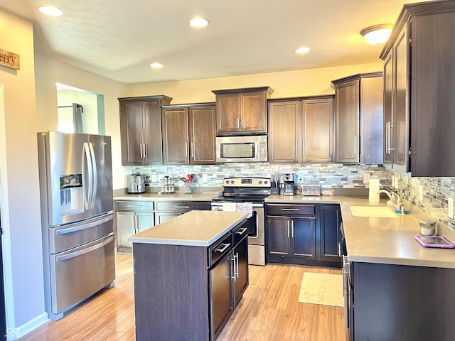 5778 W Commonview Dr, Mccordsville, IN 46055 - kitchen featuring appliances with stainless steel finishes, a sink, a kitchen island, light wood-style floors, and tasteful backsplash