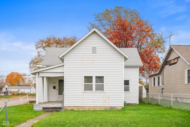 rear view of house featuring a yard