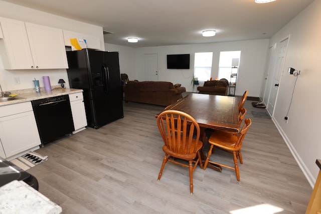 dining space featuring sink and light wood-type flooring