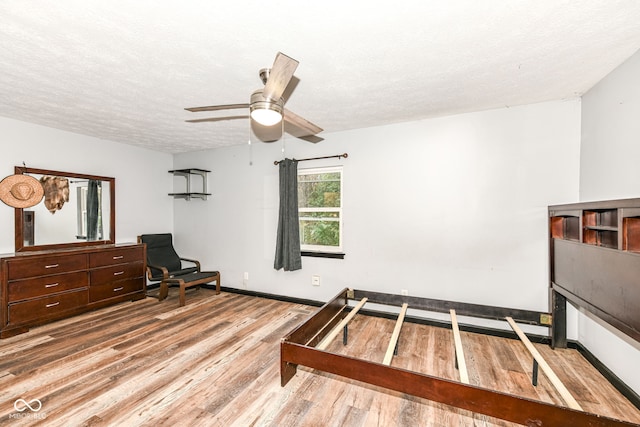 bedroom featuring ceiling fan, a textured ceiling, and light hardwood / wood-style flooring