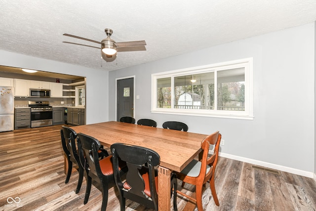 dining room featuring hardwood / wood-style floors, ceiling fan, and a textured ceiling