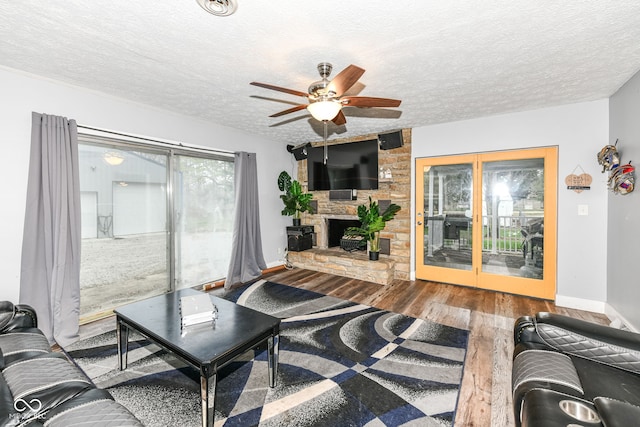 living room with a fireplace, a textured ceiling, hardwood / wood-style flooring, and ceiling fan