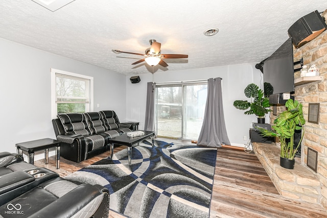 living room featuring ceiling fan, a textured ceiling, and hardwood / wood-style flooring