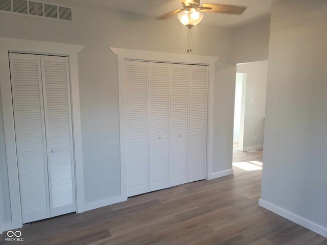 325 E Church St, Paragon, IN 46166 - unfurnished bedroom featuring wood finished floors, baseboards, two closets, and a ceiling fan
