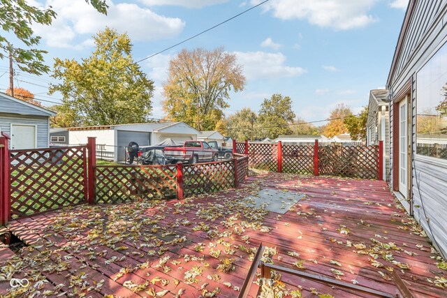 wooden deck with an outdoor structure and a garage