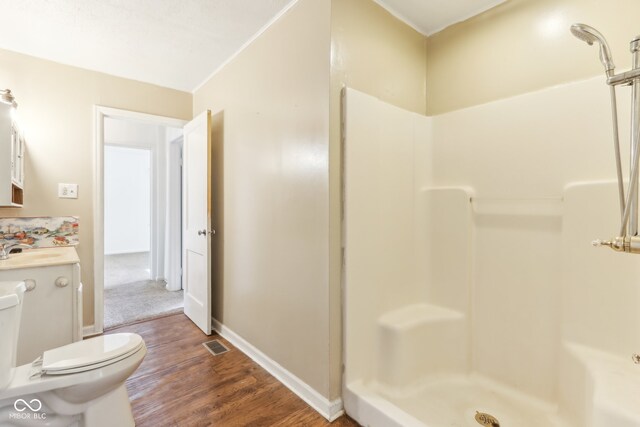 bathroom with vanity, toilet, a shower, and wood-type flooring