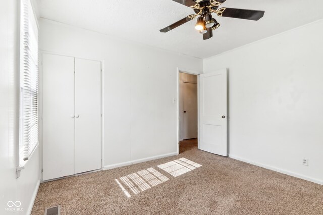 unfurnished bedroom featuring ceiling fan and light carpet