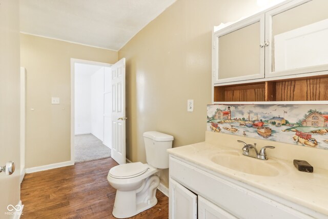 bathroom featuring vanity, toilet, and hardwood / wood-style flooring