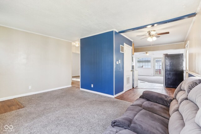 living room with ceiling fan, crown molding, and carpet flooring