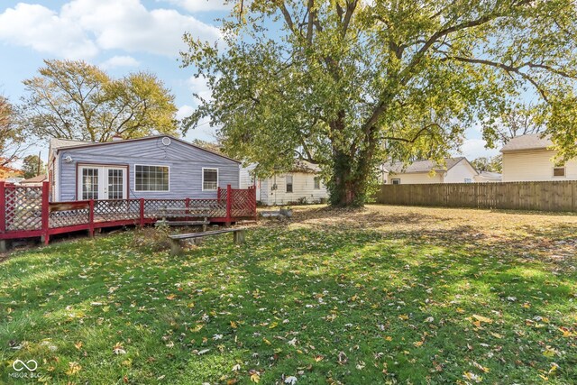 back of property with a deck and a lawn