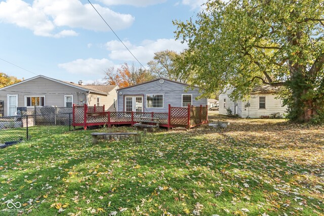 back of house with a deck and a lawn