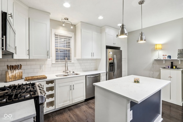 kitchen with a kitchen island, white cabinetry, hanging light fixtures, and stainless steel appliances