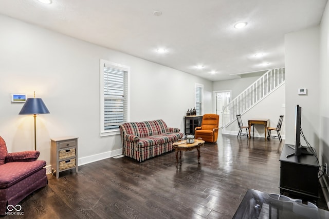 living room featuring dark wood-type flooring and a wealth of natural light