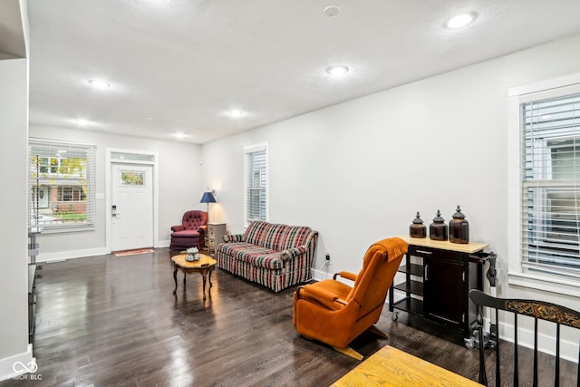 living room featuring dark wood-type flooring and a textured ceiling