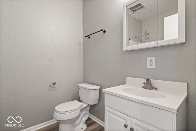 bathroom featuring vanity, hardwood / wood-style floors, and toilet