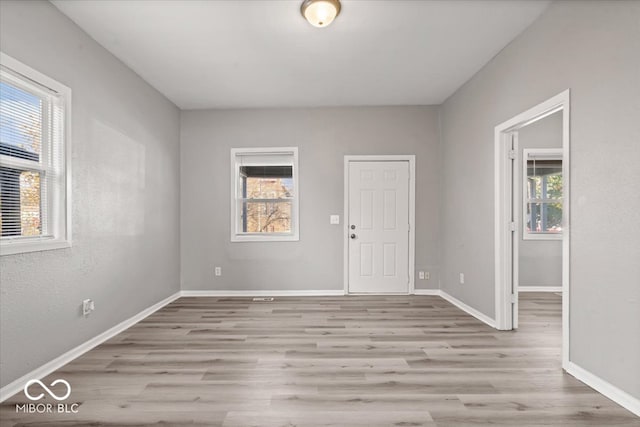 unfurnished room featuring a healthy amount of sunlight and light hardwood / wood-style flooring