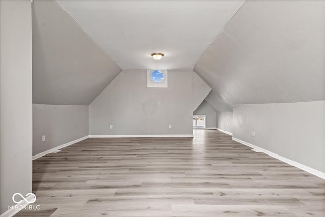 bonus room with lofted ceiling and light hardwood / wood-style floors