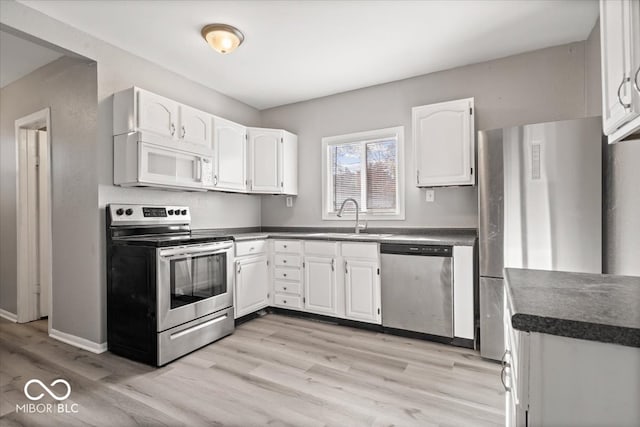 kitchen featuring stainless steel appliances, sink, light wood-type flooring, and white cabinets