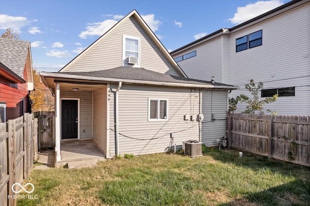 back of house with cooling unit, central AC, and a yard