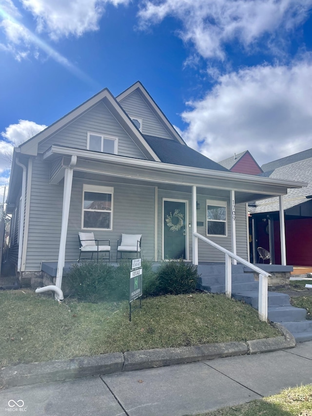 view of front of home with a porch and a front yard