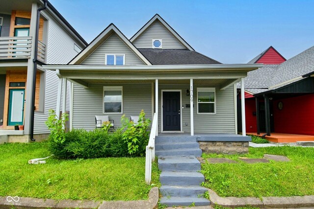 1709 Hoyt Ave, Indianapolis, IN 46203 - view of front facade featuring covered porch, roof with shingles, and a front yard