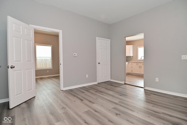 1709 Hoyt Ave, Indianapolis, IN 46203 - unfurnished bedroom featuring light wood-style floors and connected bathroom