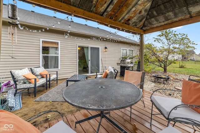 deck featuring an outdoor living space with a fire pit and a grill