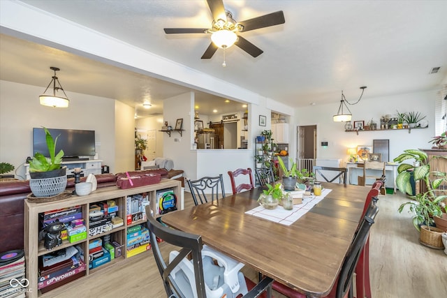 dining space with light hardwood / wood-style floors and ceiling fan