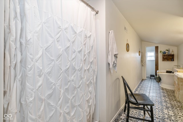 bathroom with lofted ceiling, curtained shower, and tile patterned flooring