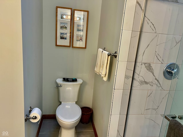 bathroom featuring tiled shower, toilet, and tile patterned flooring