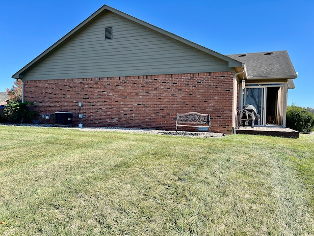 view of side of home featuring a yard and central AC unit