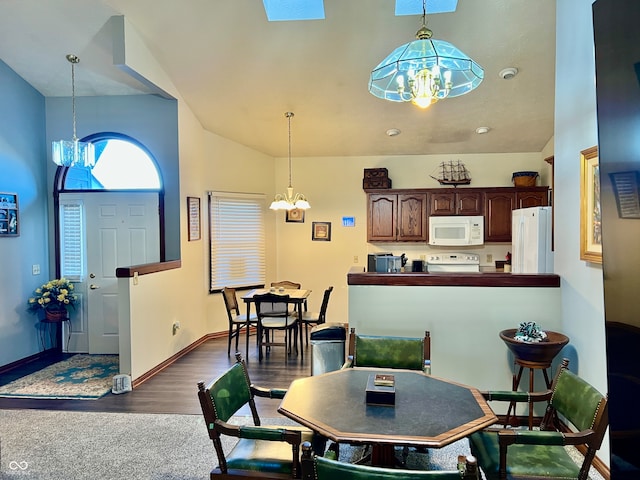 dining room with high vaulted ceiling, a notable chandelier, and dark hardwood / wood-style floors