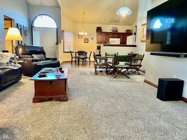 living room with a chandelier, light colored carpet, and high vaulted ceiling