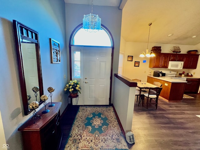 entrance foyer with dark hardwood / wood-style floors, a chandelier, and a high ceiling