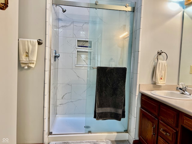 bathroom featuring vanity and a shower with shower door