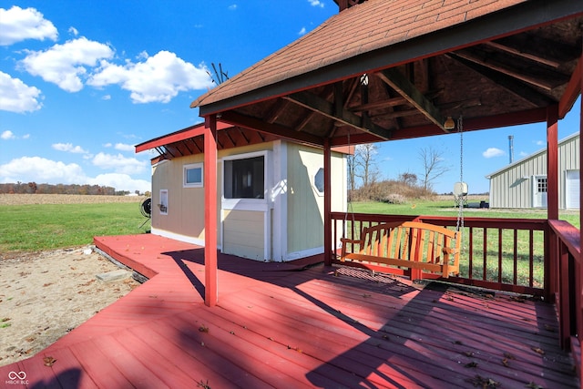 deck with a rural view, a lawn, and a gazebo