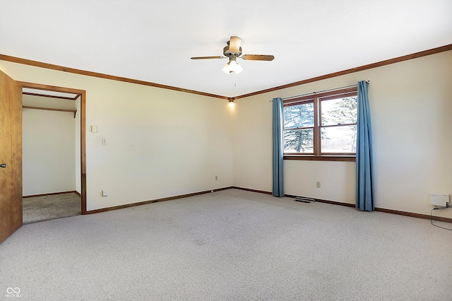 empty room with ceiling fan, light carpet, and crown molding